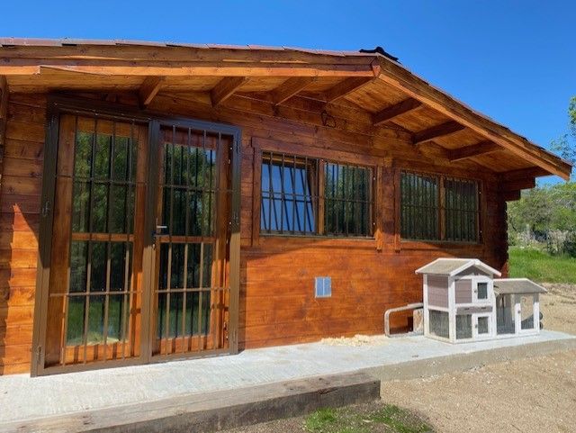 Cabaña de madera con jaulas para conejos